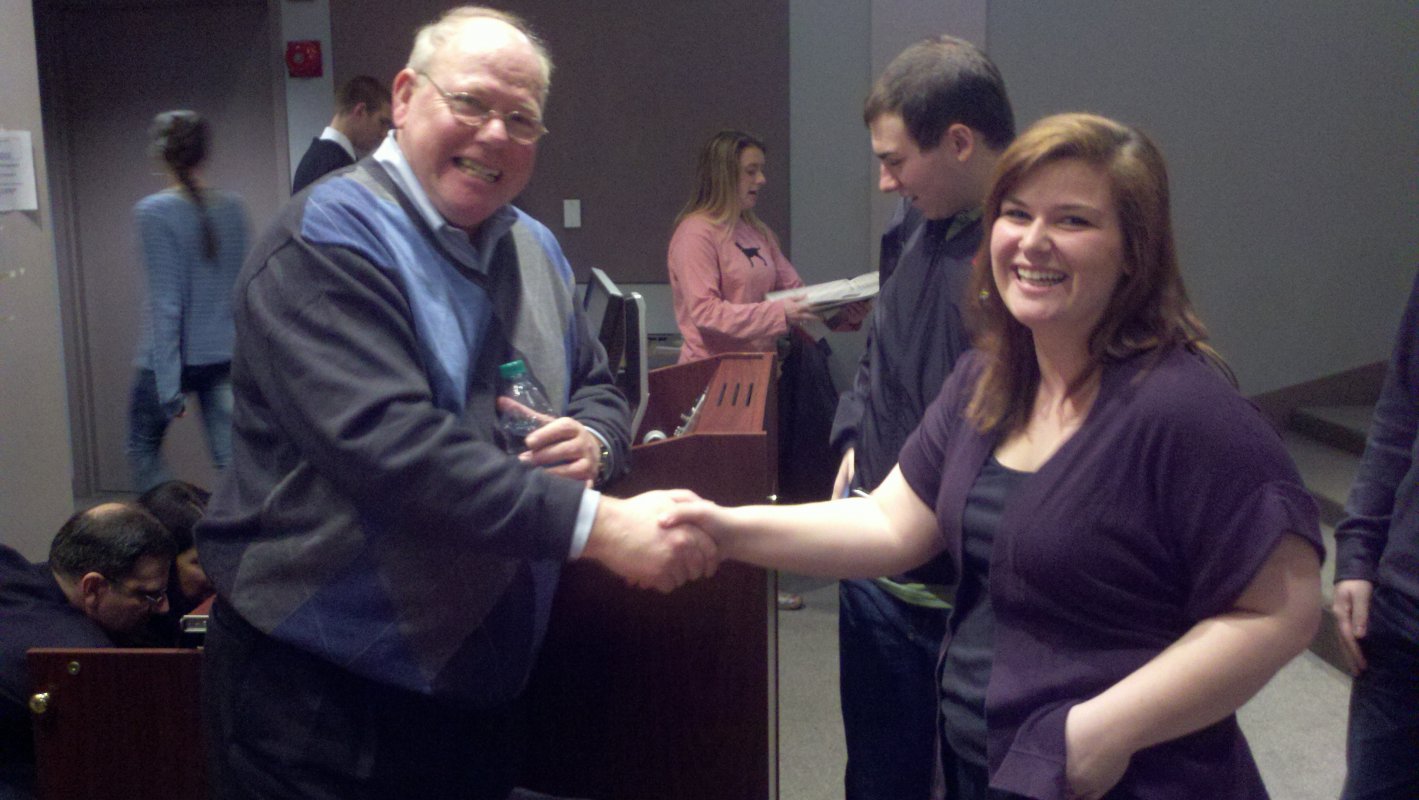 A student shakes hands with Vietnan War veteran Rick Weidman.